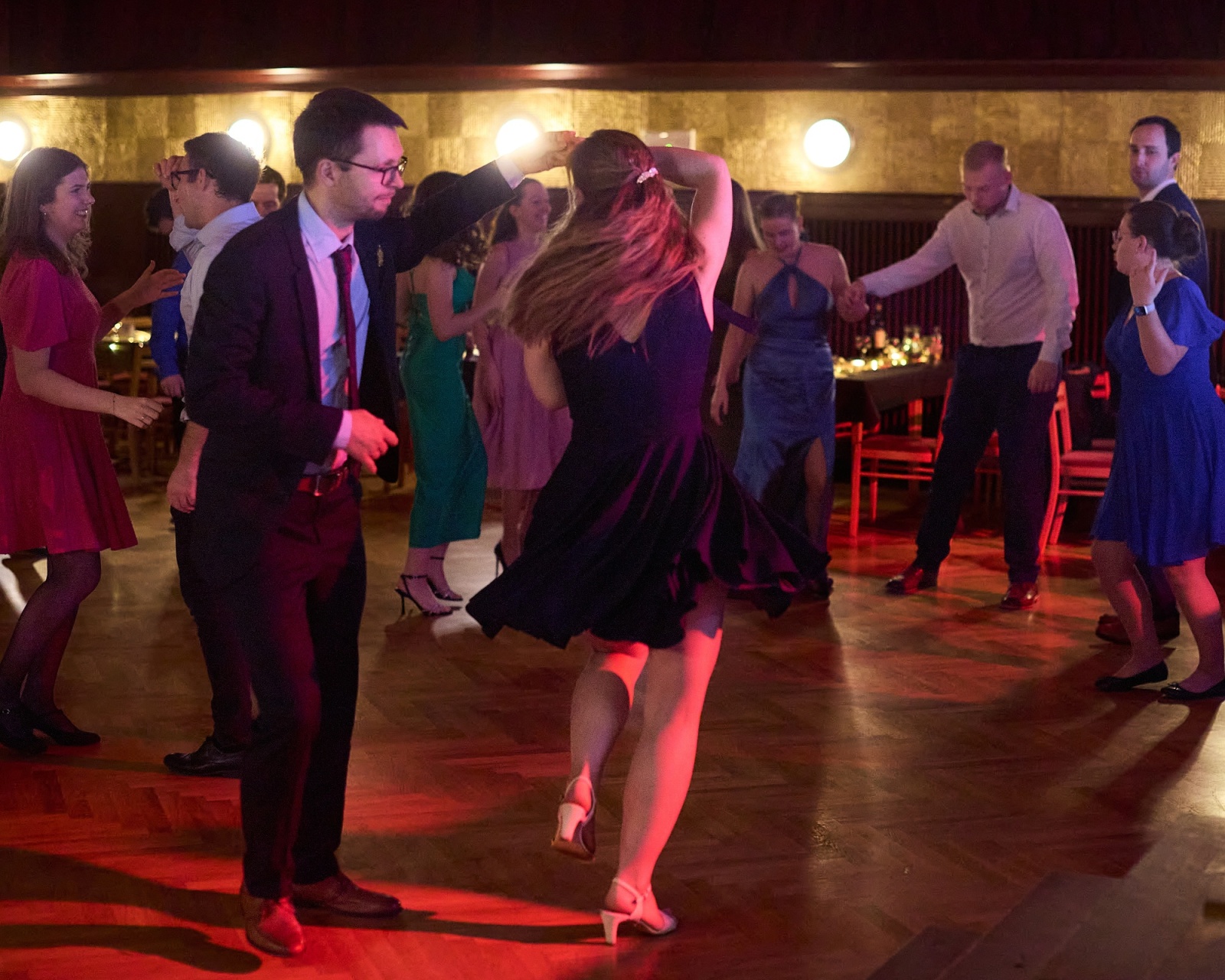 Couples dancing under warm light at a gala evening