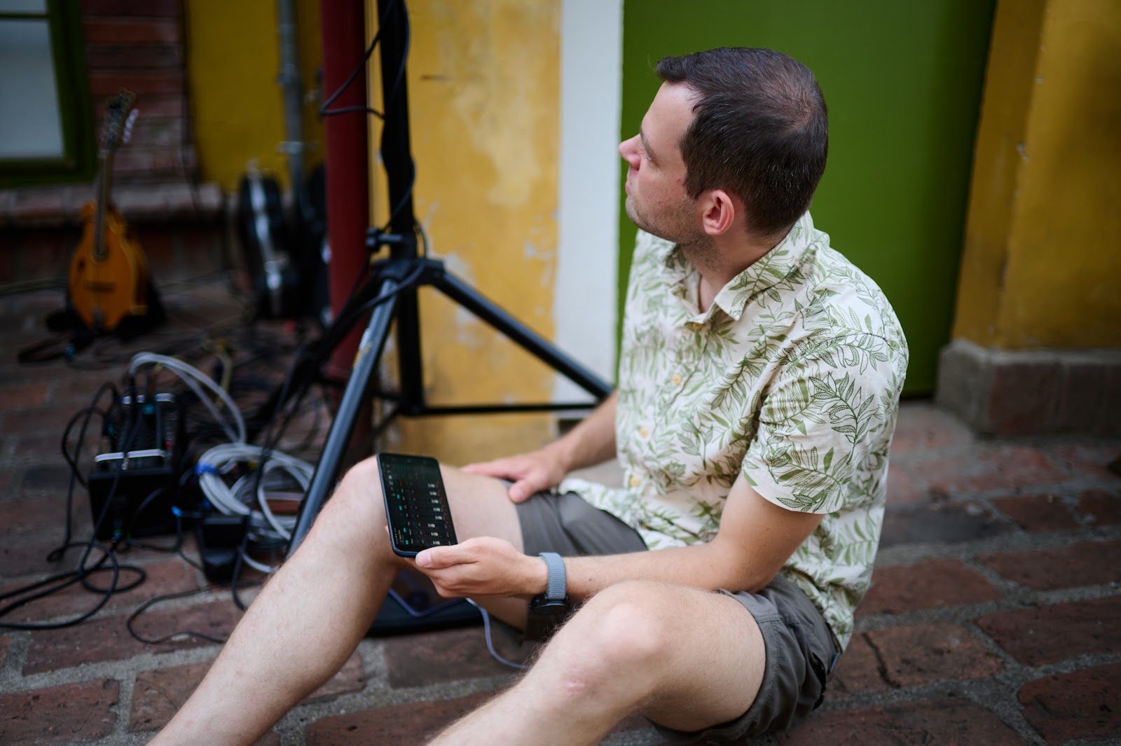 Man on a chair by a green wall, waiting for the set