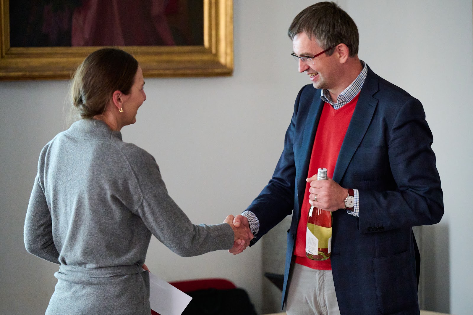 Speaker shaking hands with a guest after the talk