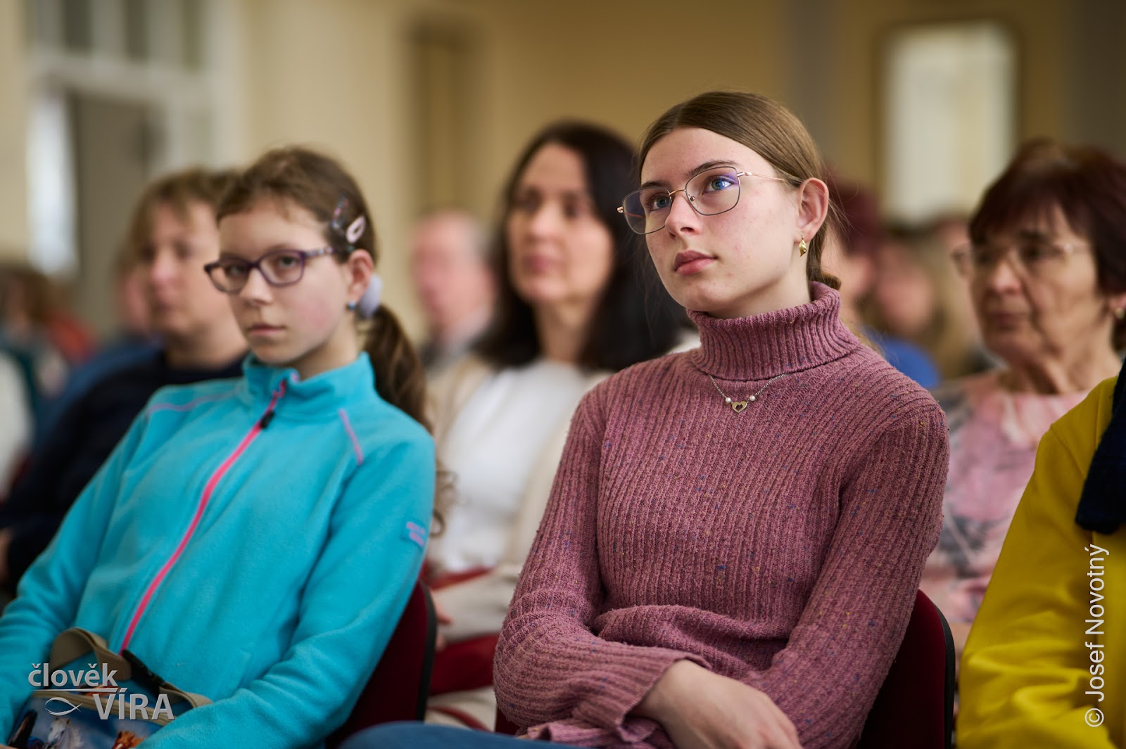 Audience listening, a young woman in the front row