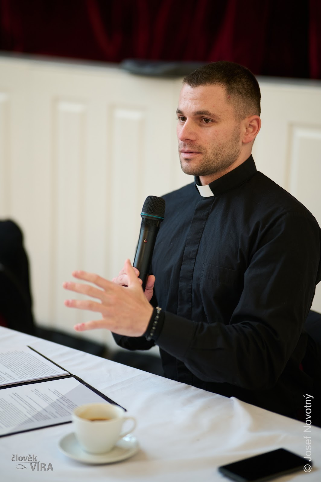 Priest speaking with a microphone