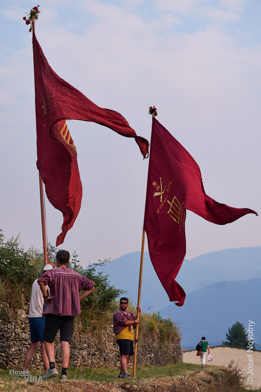 Red banners against a cloudy mountain sky