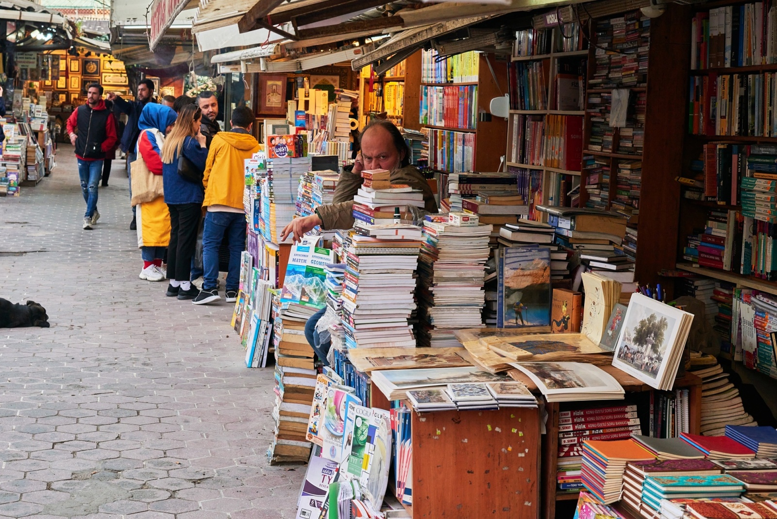 Book market stall with a seller among stacked books