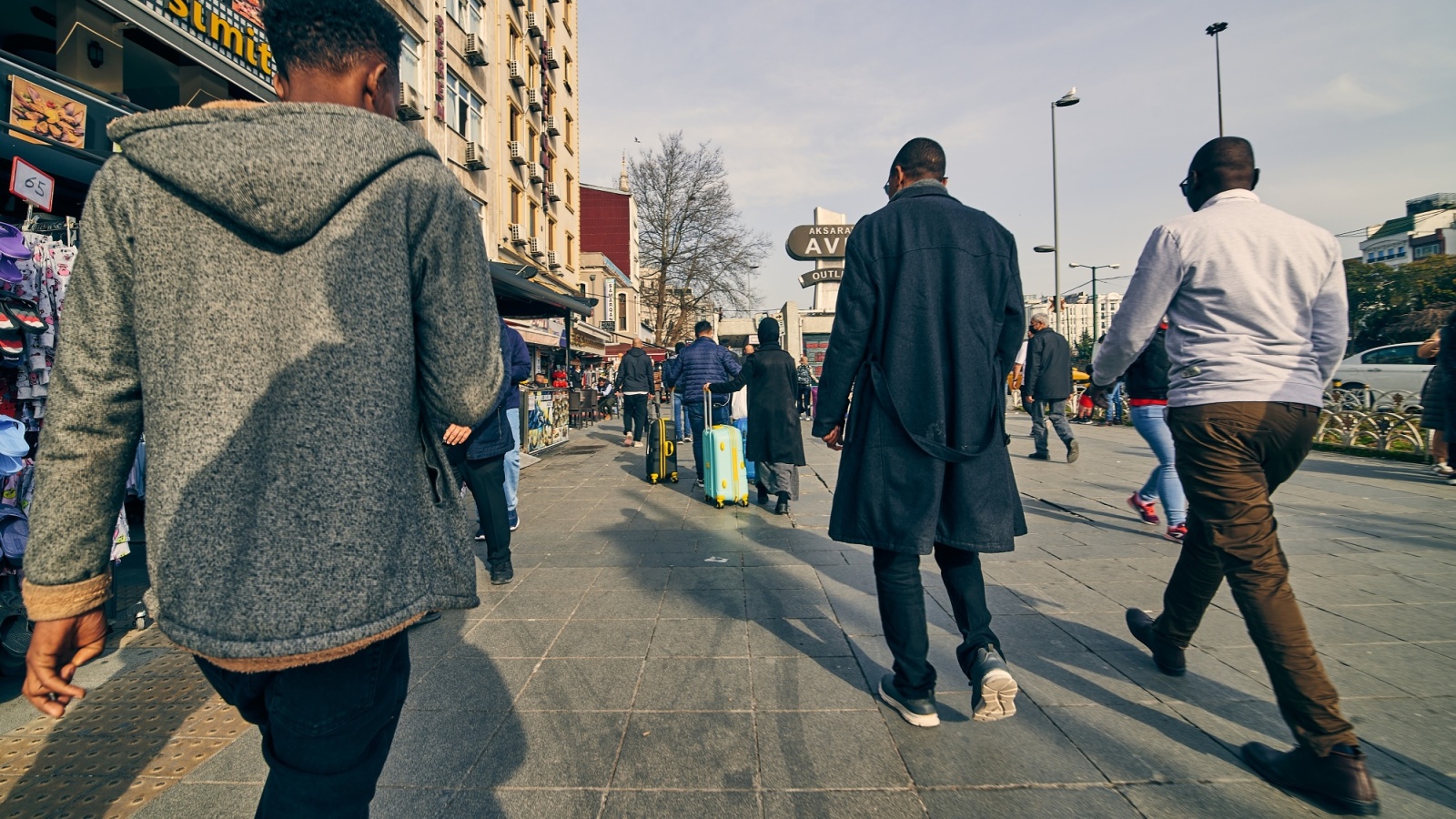 Pedestrians on a busy street in low sun